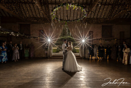 First dance couple framed by the door drapes and fairy lights above by John Fox
