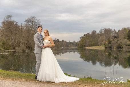 Bride and groom by a lake in Wiltshire