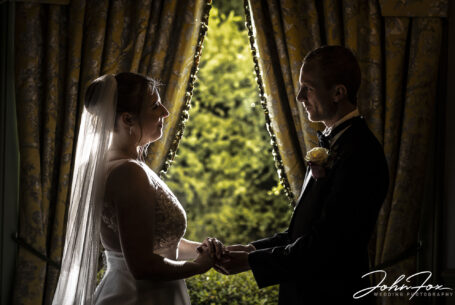 Inside Ansty Hall. Creative image of bride and groom by a window
