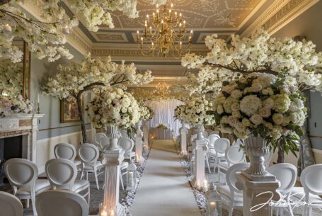 One of the ceremony rooms at Grantley Hall, North Yorkshire set ready with flowers and blossom trees