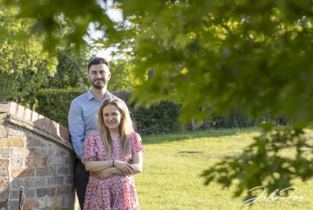 pre-wedding shoot image of bride and groom taken with evening sunlight and framed by a tree