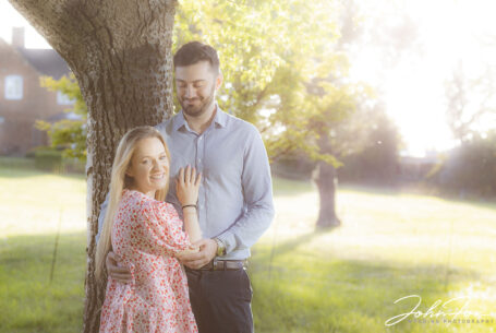 pre-wedding shoot image of bride and groom with evening sun light and soft sun flair on camera lens. Image by John Fox Wedding Photography
