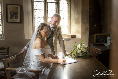 Wedding Photography for Emma and Lee in Leicestershire. Bride and groom signing the register