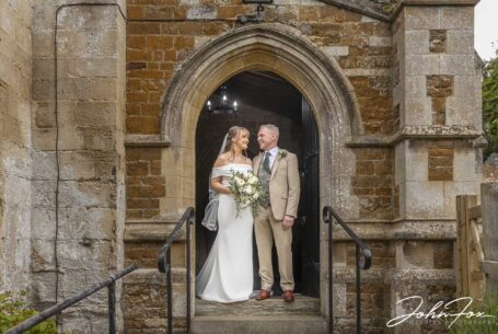 Bride and groom stood in the church doorway. Image by John Fox Wedding Photography.