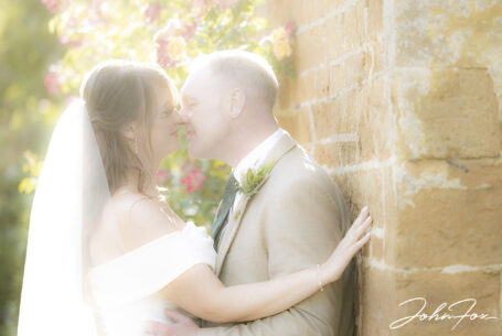 Sun soft image of the bride and groom sharing a kiss.