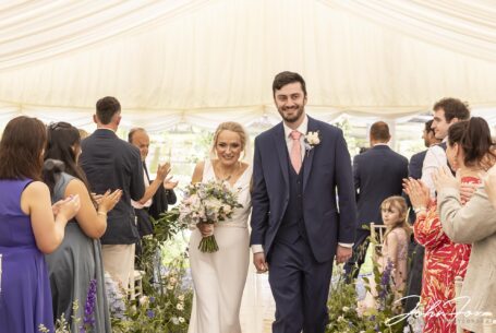 Warwickshire Wedding ceremony. The bride and groom walking up the aisle.