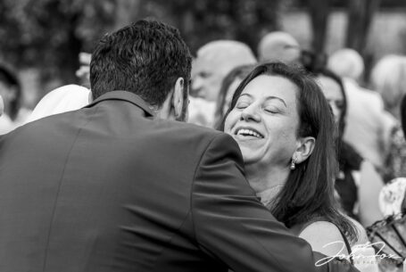 Congratulations - guests hugging the newly married couple. Black and white image by John Fox