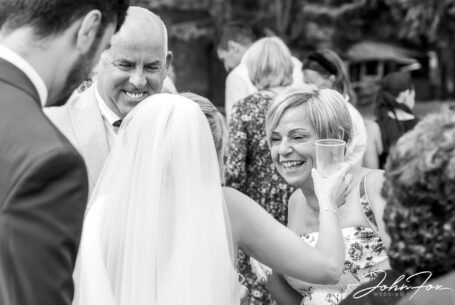Congratulations - guests hugging the newly married couple at their Warwickshire wedding