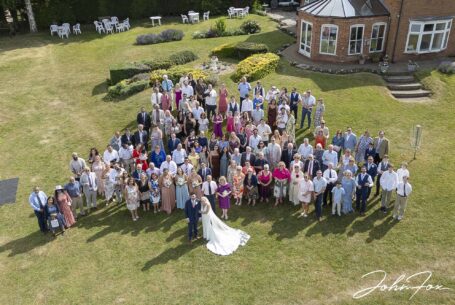 All wedding guests with bride and groom taken with a drone at the Warwickshire family home.