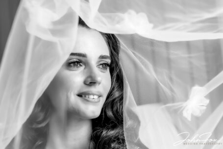 Portrait of the bride lifting her veil. Image by John Fox.