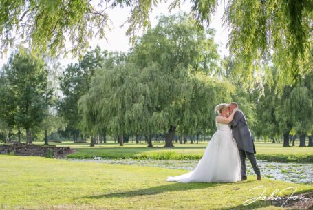 Bride and groom kissing by a pool at Braunston Golf and Country Club