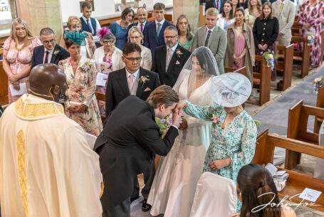 Bride being given away with groom making a traditional Philippian gesture.
