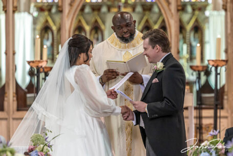 Bride and groom with the priest during the wedding ceremony in Stroud.
