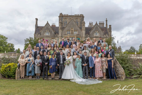 Bride and groom with all guests in the grounds at Tortworth Court.