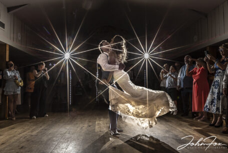 First dance photograph with groom spinning the bride in the air.
