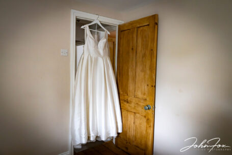 Wedding dress hanging in a doorway