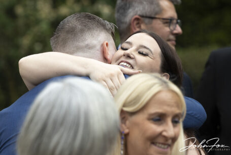 Hugs and kisses of congratulations from wedding guests. Image by John Fox.