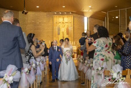 Bride and groom walking down the aisle at St Martin de Porres Church in Bedfordshire