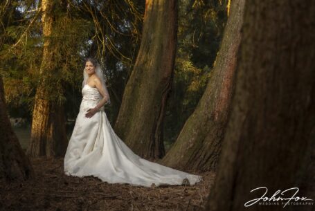 Bride in the trees in the grounds at Putteridge Hall