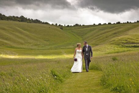 Help Planning Your Wedding Hints Tips and Advice – Part 9 - Bride and groom walking through fields at Wellington Barn, Wiltshire
