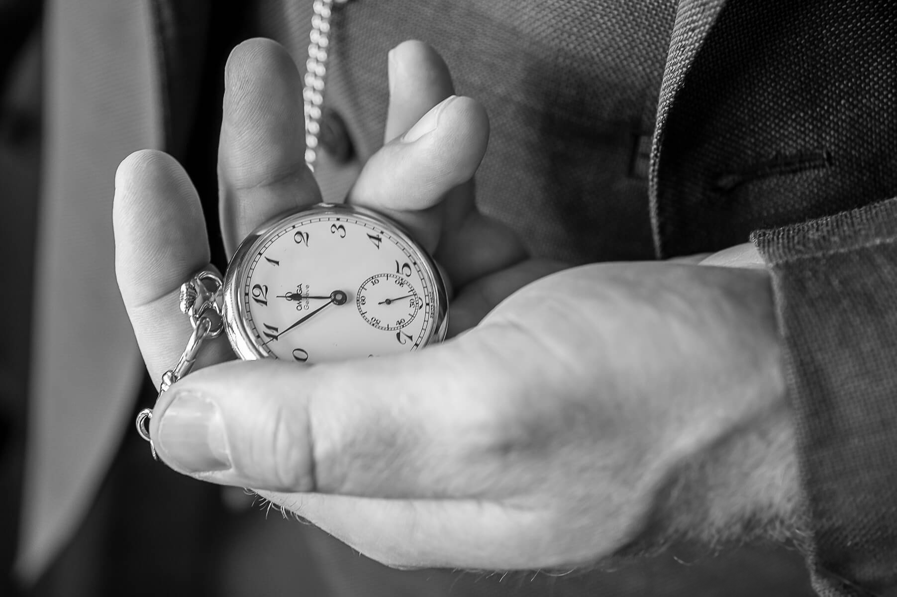 Help Planning Your Wedding - Timings: Creating a Seamless and Relaxed Timeline for your wedding. Image of a man holding his pocket watch