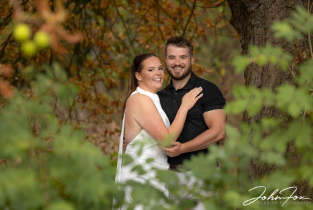 Bride and groom on their pre-wedding shoot in Rugby, captured using trees as texture and framing the image