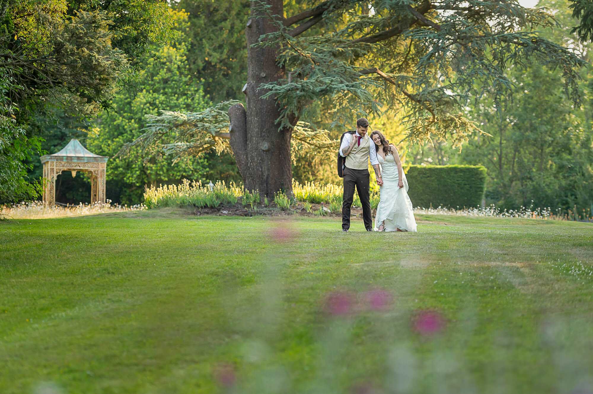 Help Planning Your Wedding Hints Tips and Advice - Staying Present and Embracing Every Moment. Image of a newly-wedded couple have a moment to themselves by walking in the wedding venue's grounds.