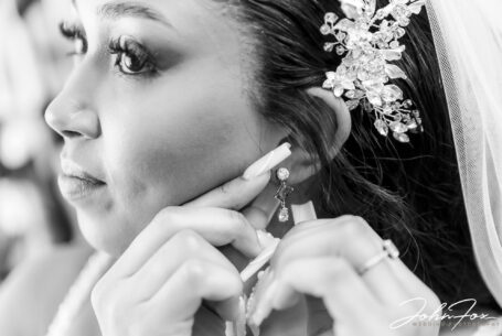 Zoe putting on her earrings. Wedding Photography in the West Midlands by John Fox Wedding Photography.
