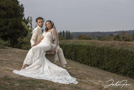 Bride and groom sitting on a bench overlooking fields at Fentham Hall