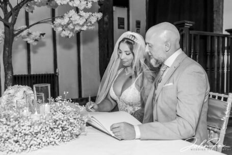 Bride and groom, Hazel and Chris, signing the register. John Fox Wedding Photography, Bedfordshire.