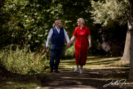 Bride and groom on a pre-wedding shoot walking in the grounds of Rushton Hall in Northamptonshire. Image by John Fox Wedding Photography.