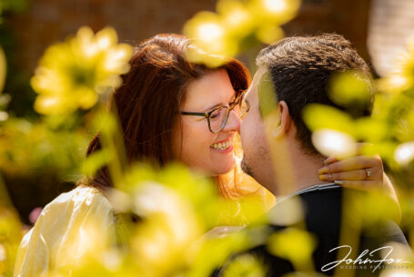Pre-wedding shoot in Leicestershire with couple photographed through flowers