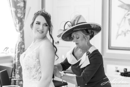 Bridal preparations - mum helping with the dress at Chicheley Hall in Buckinghamshire