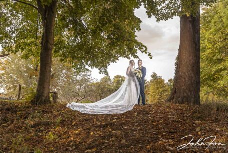 Bride and groom in woodland at Chicheley Hall in Buckinghamshire. Photo by John Fox Wedding Photography.