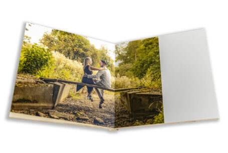 Pre-wedding shoot at Fawsley Estate in Northamptonshire for Tanya and Shane. Image of the couple sitting on a small bridge.