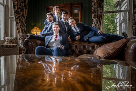 Groom and groomsmen group reflected in a table at Kilworth House