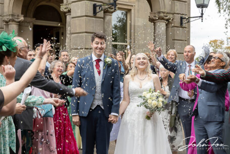 Bride and groom with guests throwing confetti over them at Kilworth House. Image by John Fox Wedding Photography.