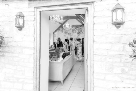 Image of bridal preparations looking into the room through a doorway at Kingscote Barn, Tetbury