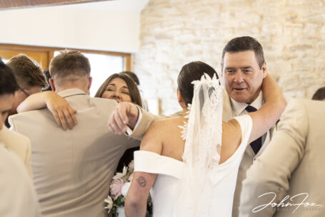 Bride and groom, Gabrielle and William, being congratulated by their wedding guests at Kingscote Barn, Tetbury