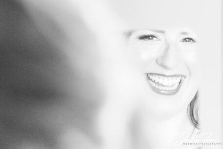 Image of Amy the bride smiling in a mirror reflection. Wedding Photography in Leicester by John Fox.
