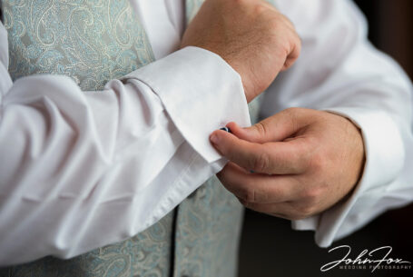 Karl the Groom fastening his cufflinks. Wedding Photography in Leicester