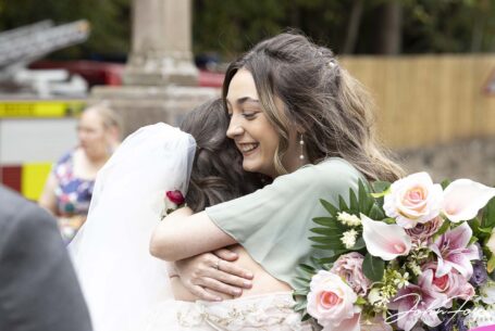 A hug for Sarah the bride from one of the guests. Staffordshire wedding photographer John Fox.