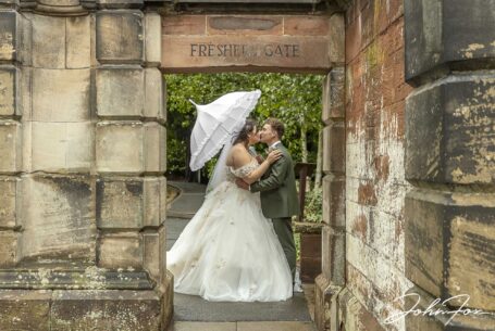 The newly weds sharing a kiss in the grounds of Keele Hall
