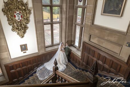 Sarah and Lewis on a grand staircase at Keele Hall in Staffordshire.