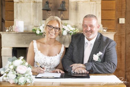 Bedfordshire Wedding ceremony, bride and groom signing the register. Image by John Fox Wedding Photography.