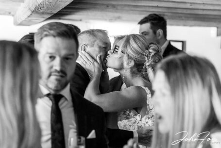 Bride being congratulated by one of her wedding guests. Wedding photographer in Bedfordshire, John Fox.