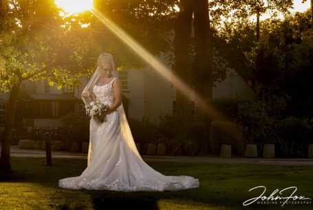 Portrait of the bride, Lynn, with golden sunlight behind her filtering through the trees. Image by John Fox Wedding Photography.