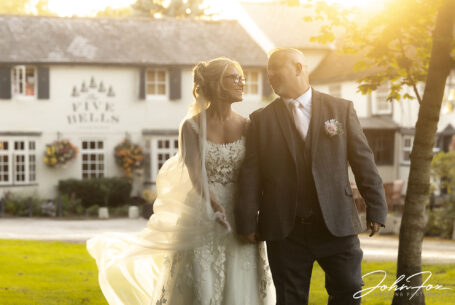 Relaxed golden hour image of bride and groom as they walk in the gardens of the Five Bells Pub in Bedfordshire