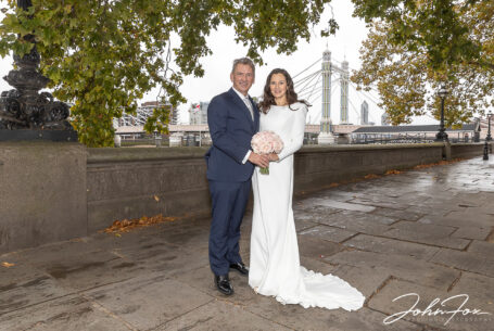 Bride and groom with Hammersmith Bridge in the background. Chelsea Registry Office Wedding images by John Fox.