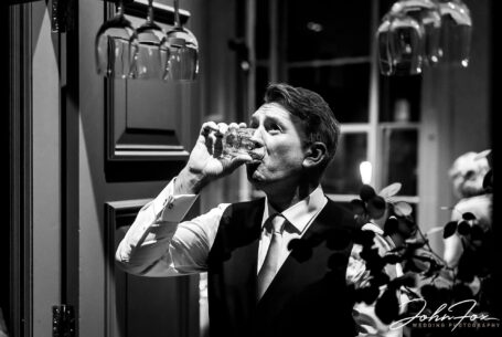 A quick one - the groom grabbing a drink before the speeches at The Phene